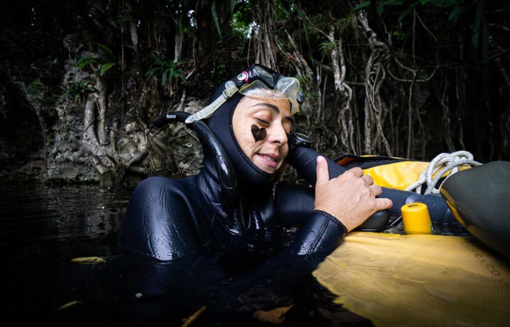 Freediver resting at the surface after an Pranamaya AIDA training dive in a jungle cenote.