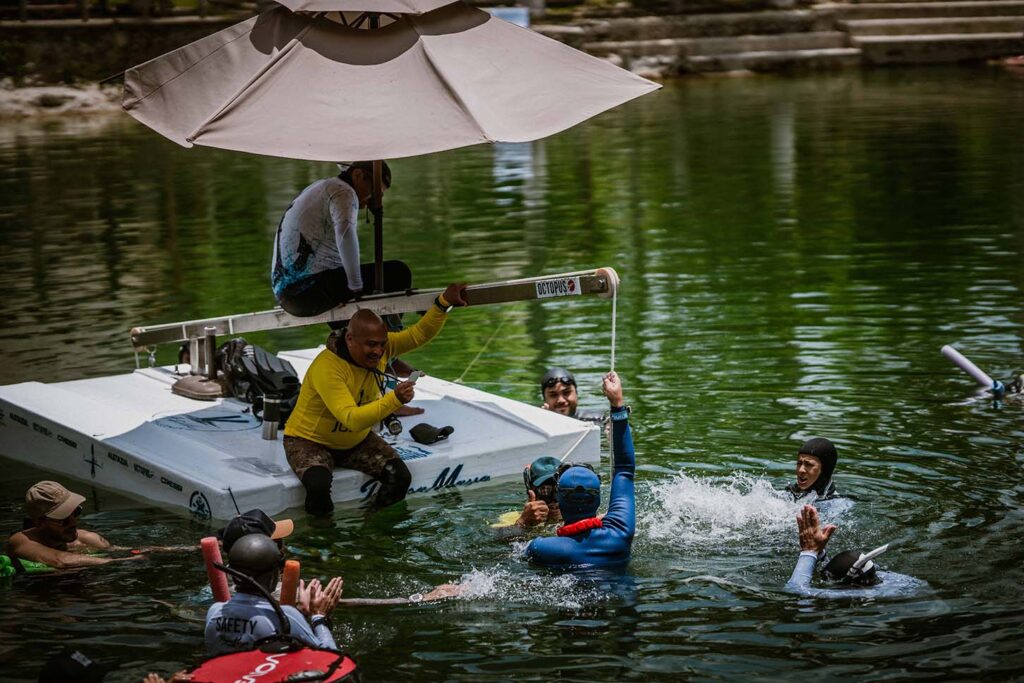 Athletes and safety team celebrating a successful dive during the Azul Freediving Challenge with Pranamaya Freediving in a Mexican cenote